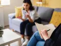 Une thérapeute prend des notes pendant une séance. Ce visuel est idéal pour un **site internet thérapeute**.